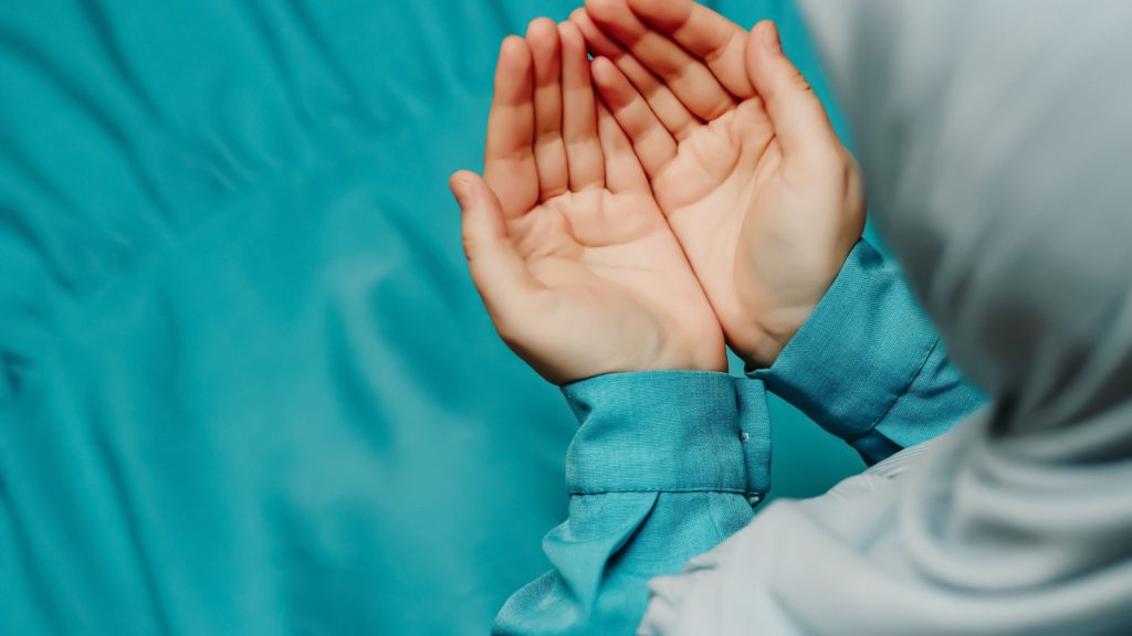 woman holding hands together in duaa