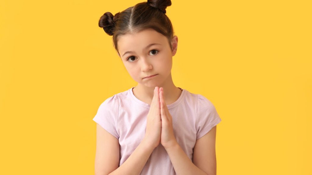 child holding her hands and looking here