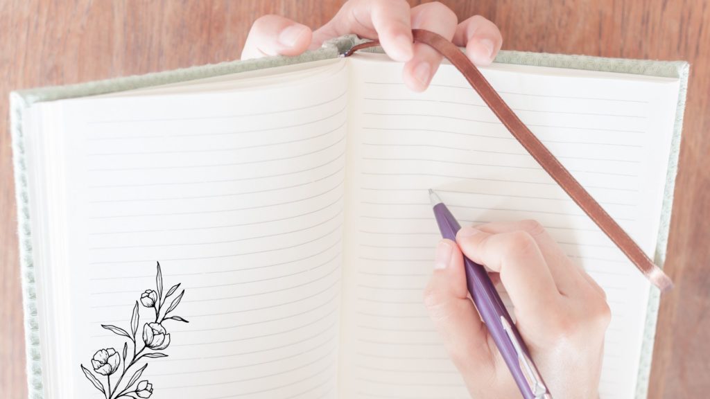 Open empty book held by a hand with a pen in another hand