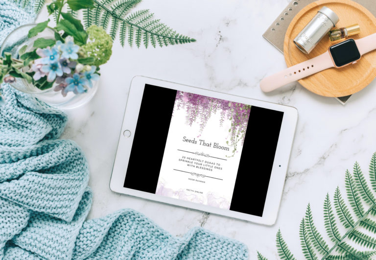 ipad with 'Seeds That Bloom' on screen lying amongst some pretty stuff like flowers