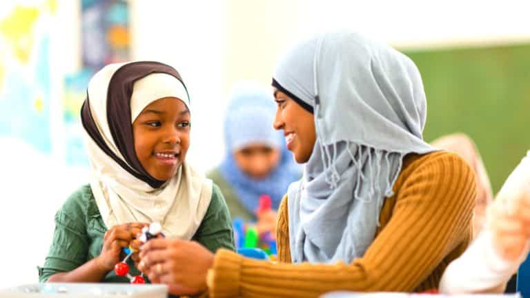 a teacher teaching a child in a classroom